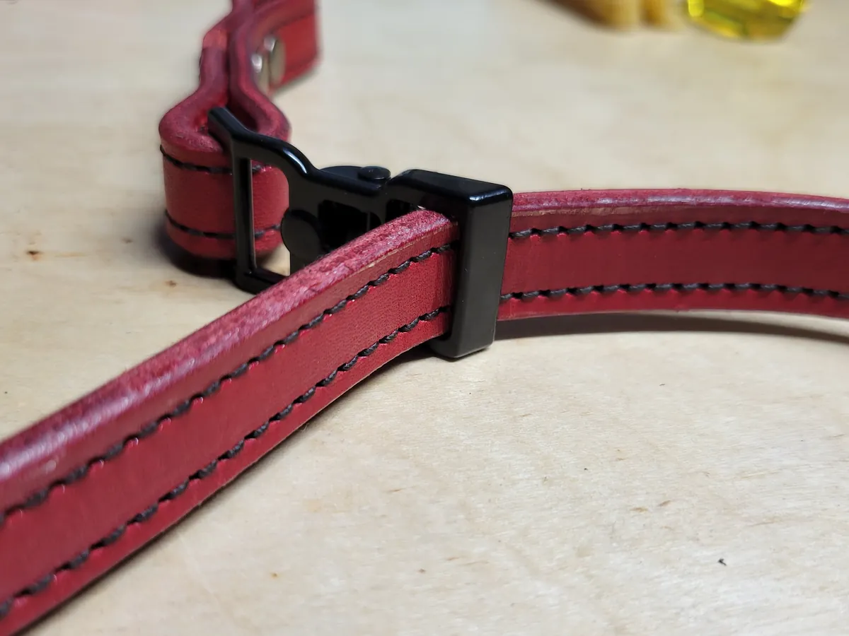 A black postman slide on a red double sewn strap
